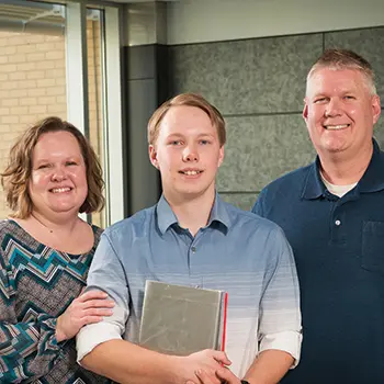 Image depicts Thrive recipient Josiah Raab with his mother on his left and father on his right