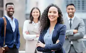 image depicts young Business Professionals standing together outside of a building